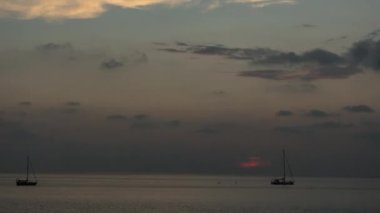 Günbatımı arka planında bir yatın silueti