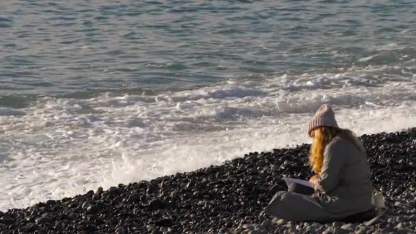 Dziewczyna czyta książkę nad morzem — Wideo stockowe