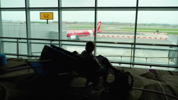 Jedna žena sedí a dívá se na letadla — Stock video