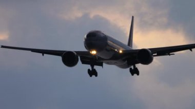 Gündoğumu arka planında uçak iniyor