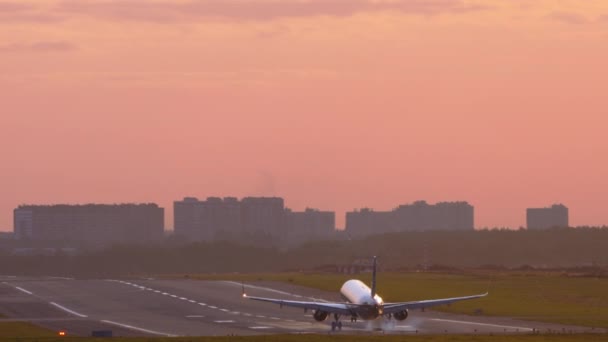 Zadní pohled na letadlo přistávající při západu slunce — Stock video