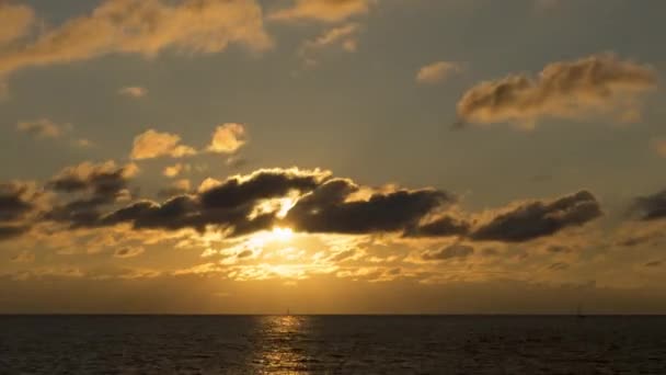 Σύννεφα στροβιλίζονται στις χρυσές ακτίνες του ήλιου — Αρχείο Βίντεο