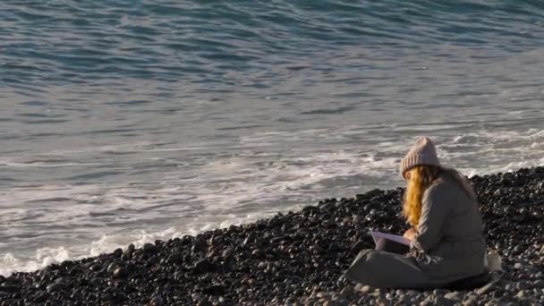 Dziewczyna czyta książkę nad morzem — Wideo stockowe