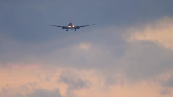 El avión vuela en el cielo nublado puesta de sol — Vídeos de Stock