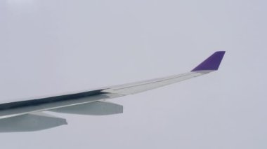 Bulutların arasından uçan uçak kanatları.