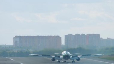 Uçak pistte fren yapıyor, dikiz manzaralı.