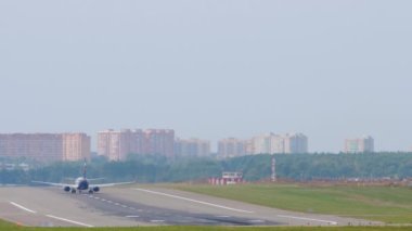 Arka taraftan uçak ve pist görünüyor.