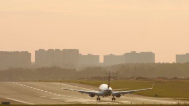 Uçak gün batımında uçar.