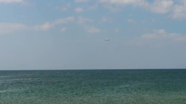 Uçak okyanusun üzerinde alçaktan uçuyor.