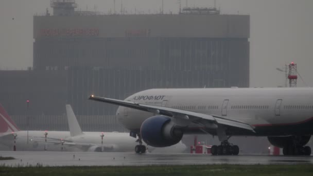 Vliegtuig en zware regenval op de luchthaven — Stockvideo