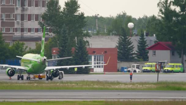 Самолет тянет трактор, вид сзади — стоковое видео