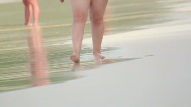 Kumsalda yürüyen bir kadın