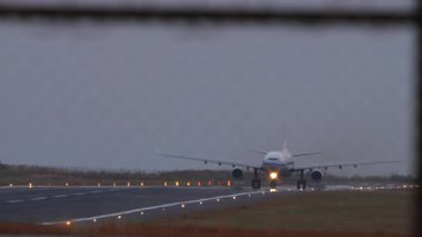 Hava kararırken pistte taksicilik yapan, yumuşak akşam ışığıyla aydınlatılan tanımlanamayan bir uçak. Atmosferik seyahat ve havacılık kavramı