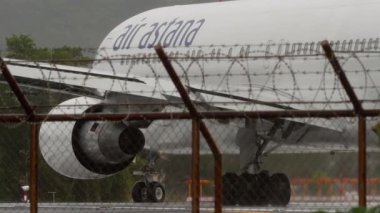 PHUKET, THAILAND - 24 Şubat 2025: Çekim, Boeing 767 uçağı, Air Astana 'dan EI-KEA Phuket havaalanındaki yağmur sırasında piste iniyor. Seyahat kavramı