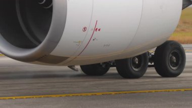 PHUKET, THAILAND - 14 Şubat 2025: Dönen türbin bıçaklarını ve detaylı metal dokularını gösteren modern bir jet motorunun yakın çekim görüntüleri. Kamera gücü ve hassasiyeti yakalar.