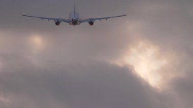 Bir uçağın bulutlu bir günbatımı gökyüzünde, dikiz görüşünde irtifa kazandığını gösteren sinematik görüntüler. Gökyüzünde bir jet. Uçak kalkıyor..