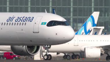 ALMATY, KAZAKHSTAN - 27 Haziran 2024: Air Astana Airbus A321, EI-KGK, Kazakistan Almaty Uluslararası Havaalanı 'ndaki piste iniyor. Bir yolcu uçağının yan görüntüsü. Havacılık ve seyahat teması.