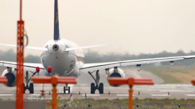 Uçak kalkış için piste yerleştirildi. Seyrüsefer ışıkları sisli ve puslu bir arka plan atmosferinde parlıyor.