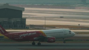 BANGKOK, THAILAND - 15 Mart 2025: Airbus A320, Vietnam Jet Air 'den HS-VKA Tayland Livery Bangkok havaalanından havalanıyor. Yolcu uçağı uçup gidiyor.