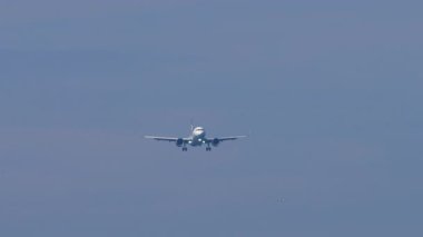 İniş pistine yaklaşan yolcu uçakları, mavi gökyüzünün altından görüldü. Uçak yolculuğu, ulaşım, havacılık endüstrisi ve ticari uçak kavramı.