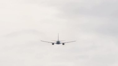 Kalkıştan sonra bulutlu gökyüzüne tırmanan ticari bir uçağın arka görüntüsü. Havacılık, seyahat ve özgürlüğün sembolik görüntüsü