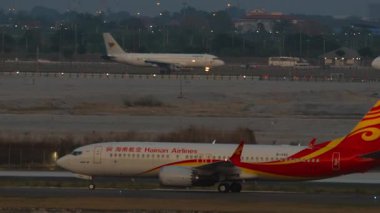 BANGKOK, THAILAND - 16 Mart 2025: Hainan Havayolları Boeing 737 MAX 8, B-1142 taksicilik, yan görüş. Yolcu uçağı pist ya da taksi yolunda. Seyahat kavramı