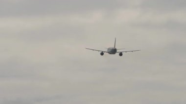 Kalkıştan sonra bulutlu gökyüzüne tırmanan ticari bir uçağın arka görüntüsü. Havacılık, seyahat ve özgürlüğün sembolik görüntüsü