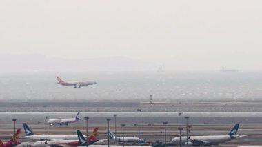 HONG KONG - 26 Ocak 2025: Hong Kong Airlines Airbus A330, B-LHH iniş pisti, uzak çekim, yan görüş. Uçak geliyor. Havaalanında uçak var.