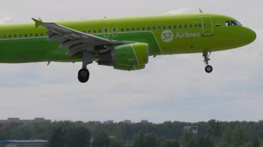 NOVOSIBIRSK, RUSYA FEDERASYONU - 15 Temmuz 2022: Ağır çekim, Airbus A320, S7 Havayolları 'ndan RA-73403 Tolmachevo havaalanına iniyor, yan görüş. Seyahat kavramı