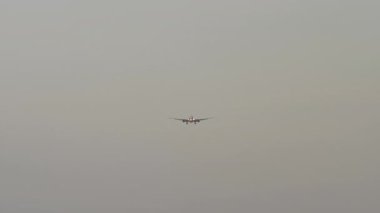 İniş için yaklaşan bir jet uçağının ön görüntüsü. İşaretsiz ticari uçak gökyüzünde uçuyor. Seyahat ve havacılık kavramı.