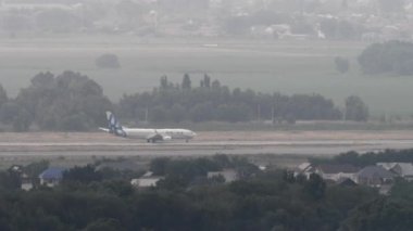 ALMATY, KAZAKHSTAN - 26 Haziran 2024: Boeing 737 SCAT Airlines ivmesi Almaty havaalanından havalanmadan önce, yan görüş, uzak çekim. Seyahat kavramı