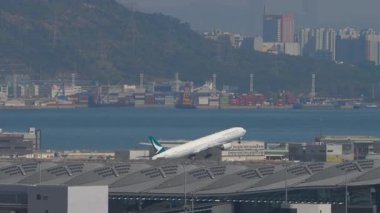 HONG KONG - 28 Ocak 2025: Boeing 777, Cathay Pacific 'ten B-HNP Chek Kap Kok havaalanından kalkış, Hong Kong, yan görüş, uzak çekim. Seyahat kavramı