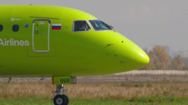 NOVOSIBIRSK, RUSSIAN FEDERASYON - 18 Eylül 2025: S7 Airlines Embraer E-170 RA-73869 Tolmchevo havaalanı pistinde, yan görüş, orta atış. Uçak pilotu görülebiliyor.
