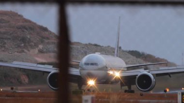 PHUKET, THAILAND - 19 Şubat 2025: Katar Havayolları A7-BAV 'nin geniş gövdeli Boeing 777' si Phuket havaalanı taksisinde. Turizm ve seyahat konsepti. Uçak taksisi, yan görüş