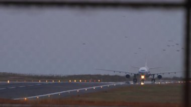 Hava kararırken pistte taksicilik yapan, yumuşak akşam ışığıyla aydınlatılan tanımlanamayan bir uçak. Atmosferik seyahat ve havacılık kavramı