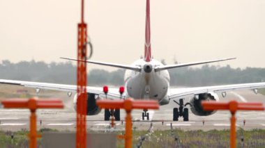 Bir yolcu jetinin kalkış için hız kazanmasının pist uçlarından perspektif.