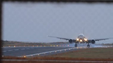 Widebody airliner landing at dusk, illuminated by soft evening light. Atmospheric travel and aviation concept