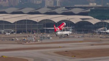 HONG KONG - 28 HAZİRAN 2025 Airbus A320 AirAsia yolcuları düşük maliyetli kalkış Chek Kap Kok havaalanı, Hong Kong, yan görüş