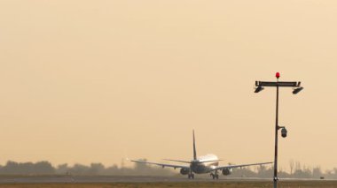 Tanınmayan bir üniforması olan, havalanan, tırmanan, dikiz aynasından bakan bir uçak. Jet uçağı uçuyor. Güzel gündoğumunda gökyüzünde uçaklar
