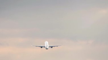 Kalkıştan sonra yükselen markasız üniformalı bir uçak perspektifi, hava yolculuğunu ve küresel seyahatleri sembolize ediyor.