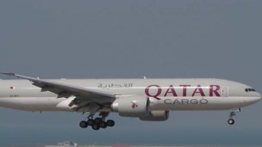 HONG KONG - 29 Ocak 2025: Boeing 777, Katar Kargo A7-BFX Chek Kap Kok havaalanına iniş, yan görüş. Kargo jeti geliyor. Beneklenme