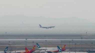 HONG KONG - 26 Ocak 2025: uzak çekim, yolcu uçağı Airbus A330, B-HLS Cathay Pacific iniş. Seyahat konsepti. Beneklenme