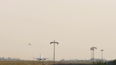 Tanınmayan bir üniforması olan, havalanan, tırmanan, dikiz aynasından bakan bir uçak. Jet uçağı uçuyor. Güzel gündoğumunda gökyüzünde uçaklar