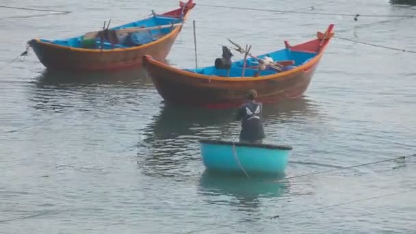 Рыбак на круглой лодке в море — стоковое видео