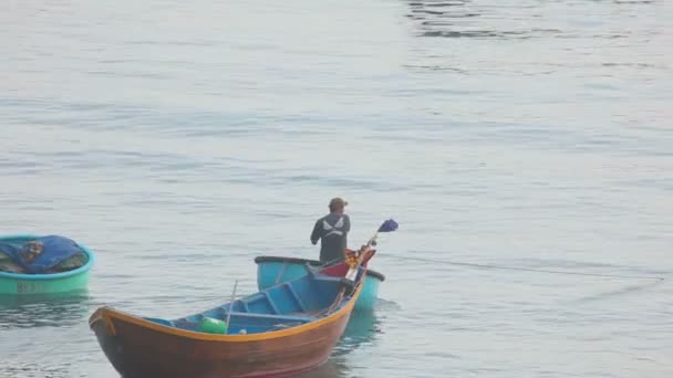 Pescador en un bote redondo hacia el mar — Vídeo de stock