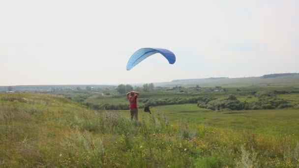 Paragliders i naturen, nära byn — Stockvideo