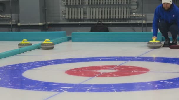 Spelare slår en curling stone — Stockvideo