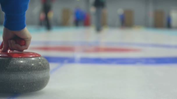 Spelaren rullar en curling stone — Stockvideo