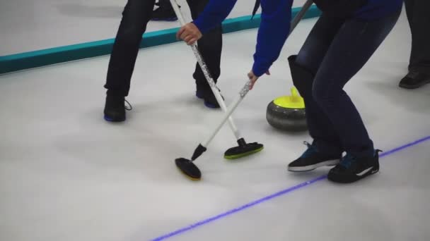 Curling kamień slajdów, gracze zamiatanie — Wideo stockowe