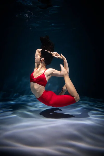 少女はスポーツ服を着て水中でヨガに従事している 瞑想における没入 — ストック写真